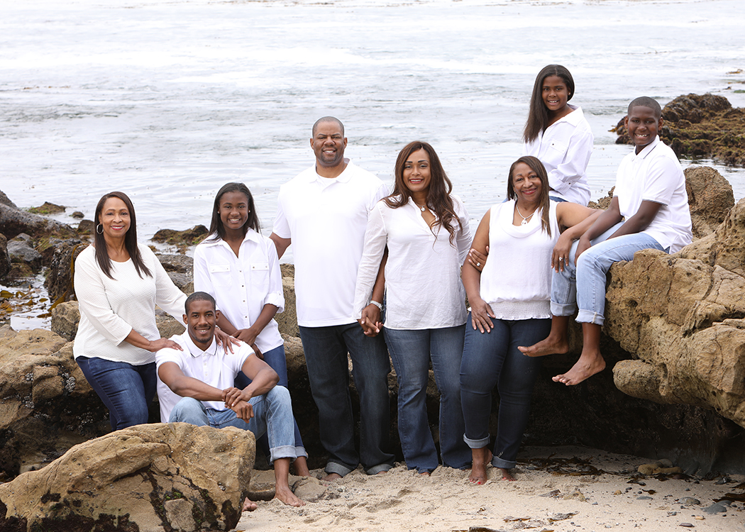 Martell and family posed in large rocks at the beach